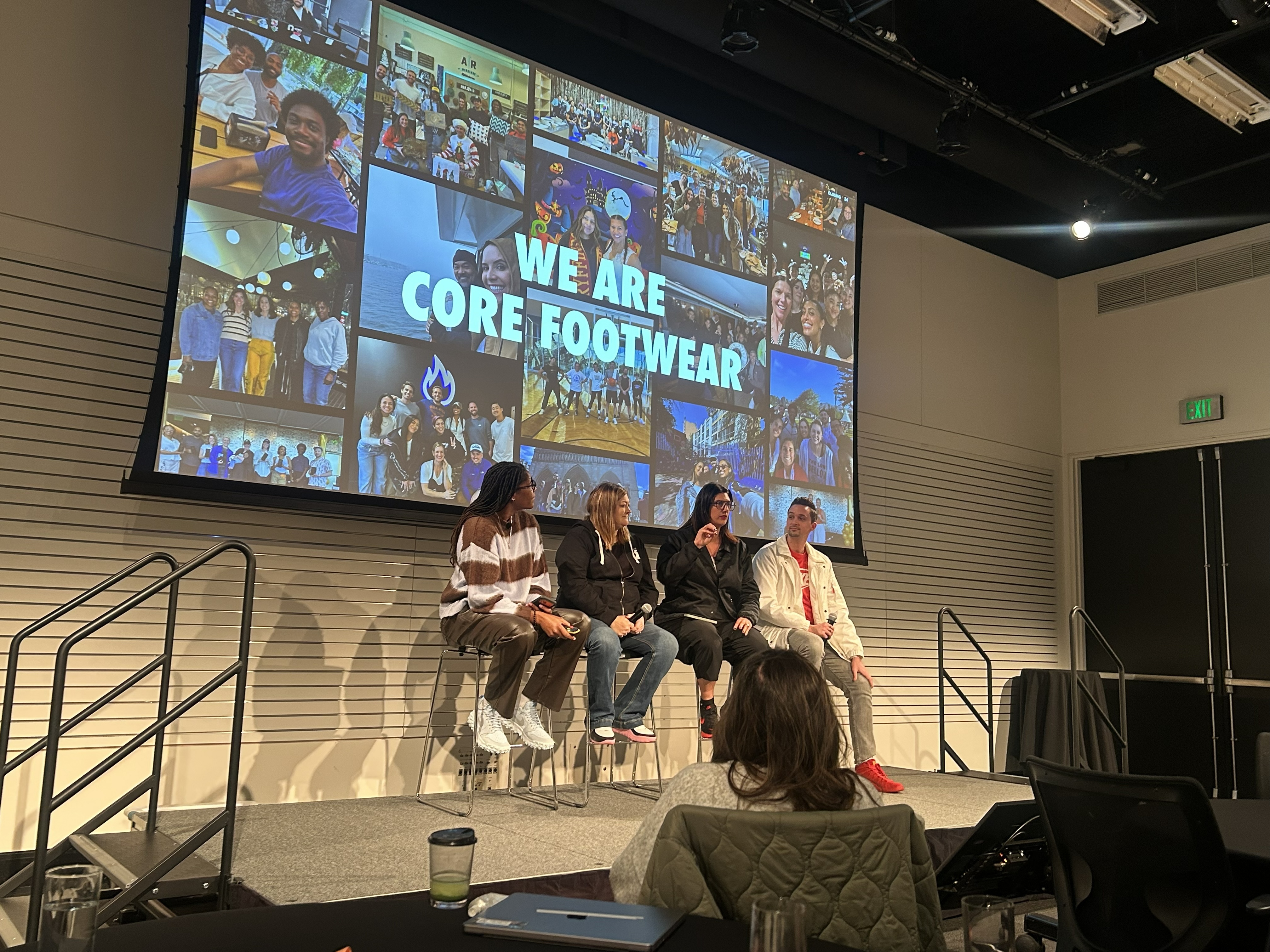 Michelle Snow on a Core Footwear panel in front of a large team photo collage